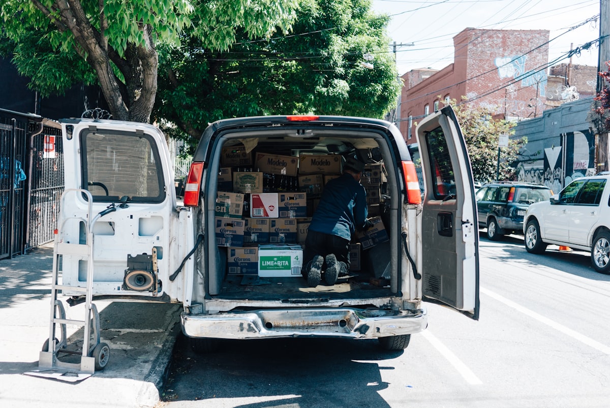 Transportista organizando cajas en el interior de una furgoneta de reparto
